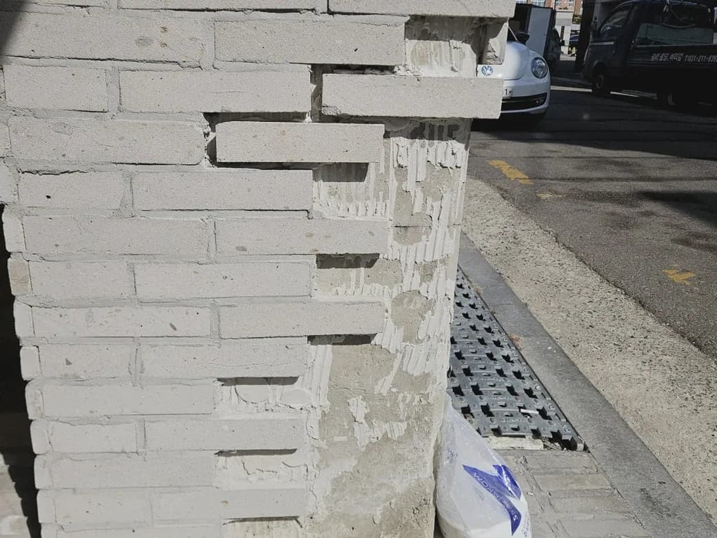 파벽돌이 깨져 속이 드러난 주차장 기둥